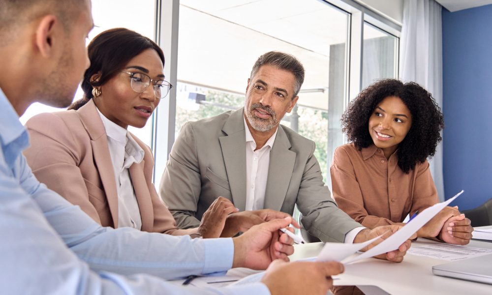 Busy diverse professional executive business law experts team diverse colleagues employees work group consulting planning financial strategy having conversation at conference office corporate meeting.