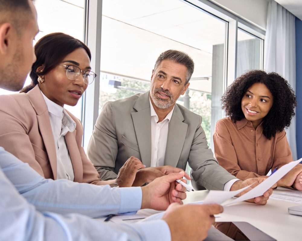 Busy diverse professional executive business law experts team diverse colleagues employees work group consulting planning financial strategy having conversation at conference office corporate meeting.